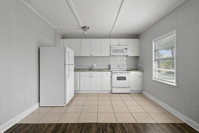 652 Bayberry Dr, Lake Park, FL 33403 - kitchen featuring white appliances, light tile patterned floors, a sink, light stone counters, and white cabinets