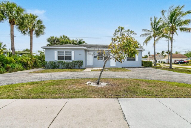 652 Bayberry Dr, Lake Park, FL 33403 - view of front of house featuring driveway, a front lawn, and stucco siding