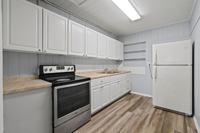 652 Bayberry Dr, Lake Park, FL 33403 - kitchen with light countertops, stainless steel range with electric stovetop, a sink, freestanding refrigerator, and white cabinets