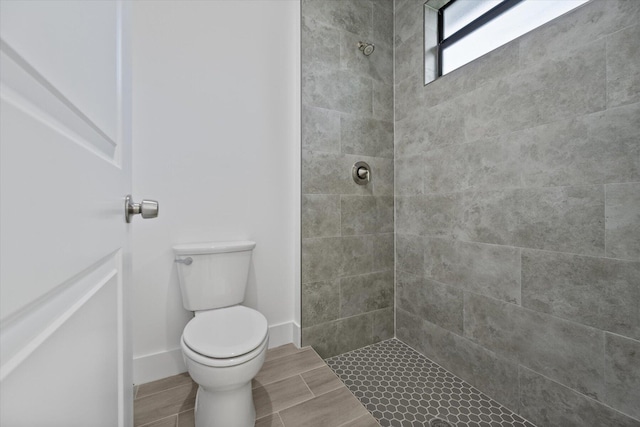 bathroom featuring toilet and a tile shower