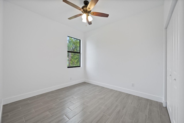 unfurnished room featuring baseboards, a ceiling fan, and light wood-style flooring