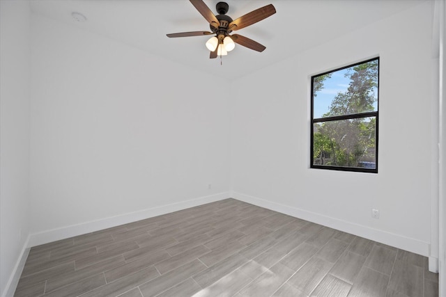 empty room featuring baseboards, a ceiling fan, and wood finished floors