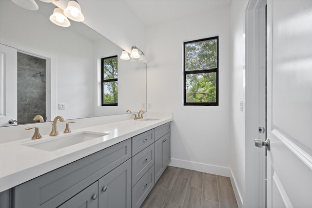 bathroom featuring baseboards, plenty of natural light, and a sink