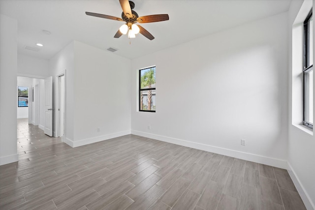 empty room with baseboards, plenty of natural light, and light wood-type flooring