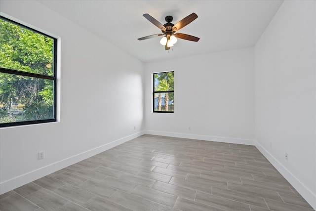 spare room featuring a ceiling fan, baseboards, and wood finished floors