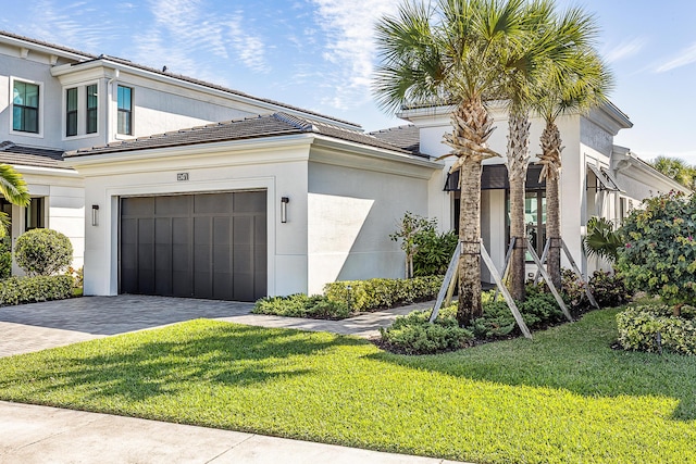 13471 Artisan Cir, Palm Beach Gardens, FL 33418 - view of front of house featuring a front yard, driveway, a tiled roof, and an attached garage