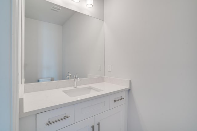bathroom featuring visible vents, toilet, and vanity