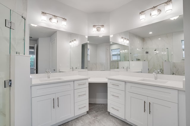 bathroom with two vanities, a sink, and a marble finish shower