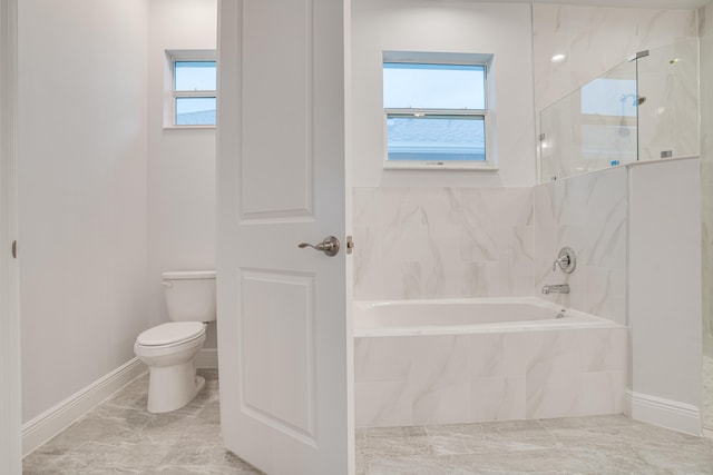 full bathroom featuring a garden tub, baseboards, a marble finish shower, and toilet