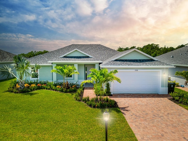 single story home with a front yard, roof with shingles, stucco siding, decorative driveway, and a garage