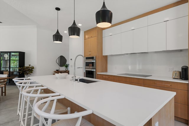 2651 Players Ct, Wellington, FL 33414 - kitchen with black electric cooktop, a sink, stainless steel double oven, light countertops, and modern cabinets