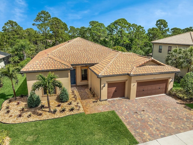 mediterranean / spanish home with an attached garage, stucco siding, a tile roof, and decorative driveway