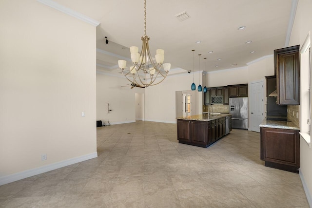 kitchen featuring crown molding, open floor plan, a kitchen island with sink, stainless steel refrigerator with ice dispenser, and a notable chandelier