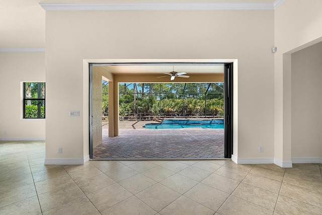 entryway featuring ornamental molding, tile patterned floors, ceiling fan, and baseboards