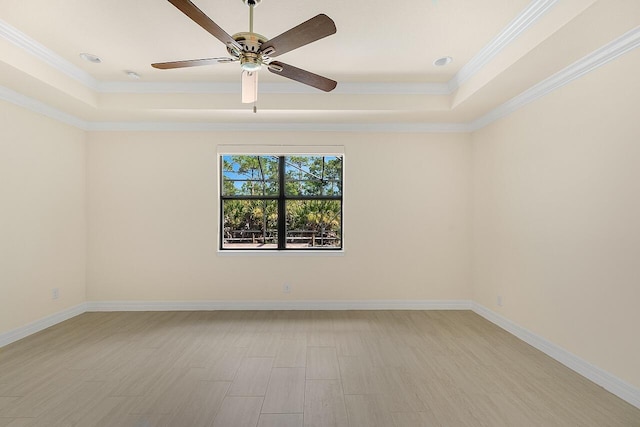 unfurnished room featuring ornamental molding, a tray ceiling, ceiling fan, and baseboards