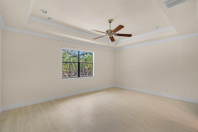 unfurnished room featuring baseboards, ornamental molding, a raised ceiling, visible vents, and ceiling fan