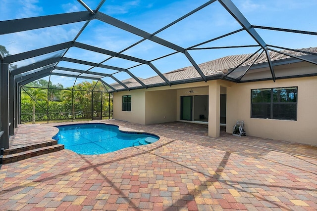 pool featuring a patio area, glass enclosure, and a ceiling fan