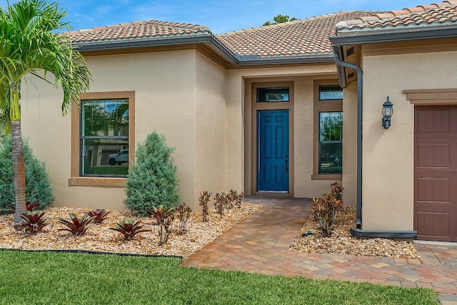 property entrance featuring stucco siding and a tiled roof