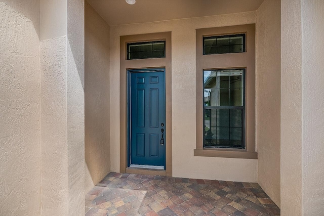 doorway to property featuring stucco siding