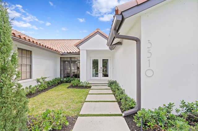 3510 Embassy Dr, West Palm Beach, FL 33401 - property entrance featuring french doors, a yard, a tile roof, and stucco siding