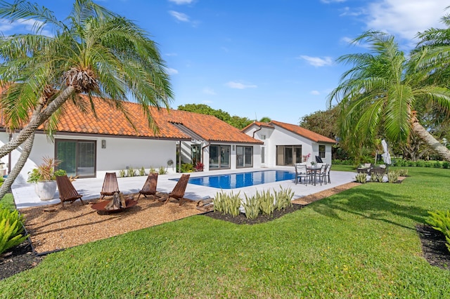 3510 Embassy Dr, West Palm Beach, FL 33401 - back of property with a patio, an outdoor pool, stucco siding, a tile roof, and a lawn