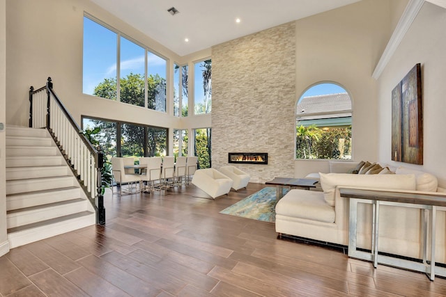 6131 NW 30th Ave, Boca Raton, FL 33496 - living area with visible vents, stairs, a fireplace, a high ceiling, and wood finished floors