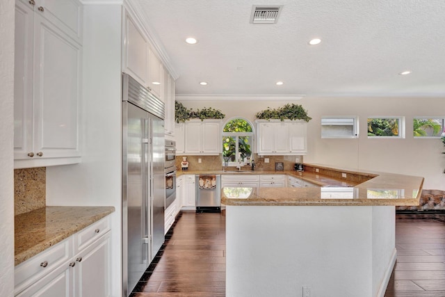 6131 NW 30th Ave, Boca Raton, FL 33496 - kitchen featuring visible vents, dark wood-type flooring, white cabinetry, stainless steel appliances, and decorative backsplash