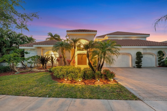 6131 NW 30th Ave, Boca Raton, FL 33496 - mediterranean / spanish-style home with a garage, decorative driveway, stucco siding, and a tile roof
