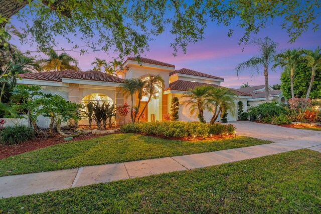 6131 NW 30th Ave, Boca Raton, FL 33496 - mediterranean / spanish house featuring stucco siding, driveway, a tile roof, and a lawn