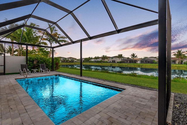 pool at dusk with a water view, a patio, an outdoor pool, and glass enclosure