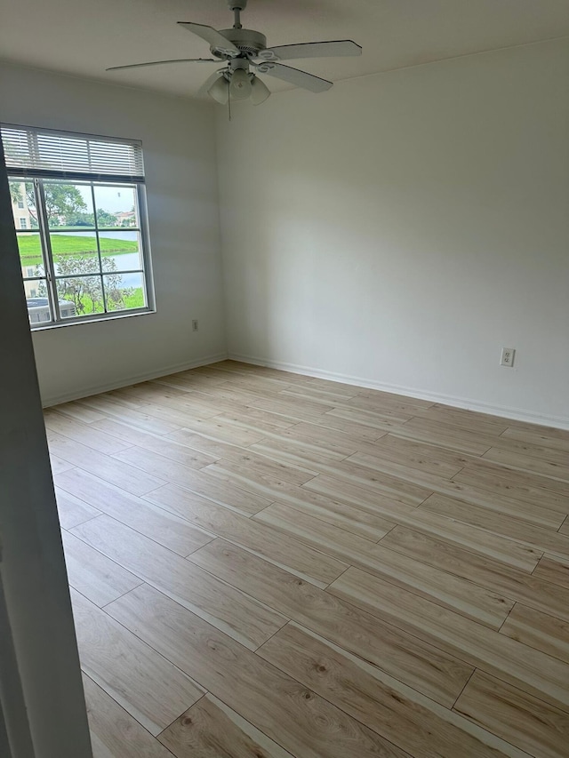 unfurnished room with light wood-style flooring, baseboards, and ceiling fan