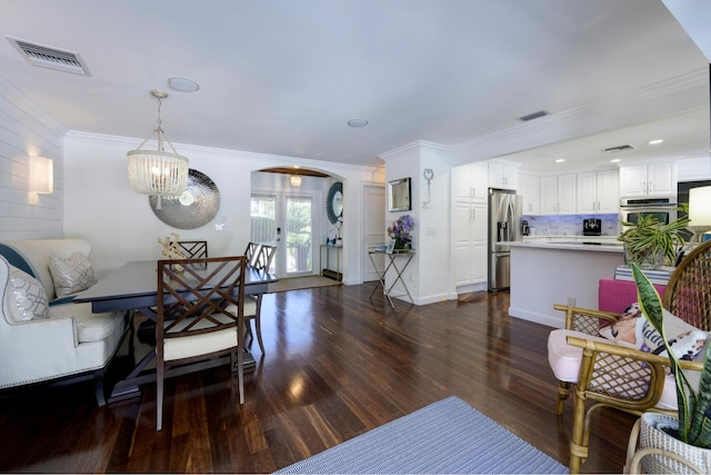 11753 Landing Pl, Palm Beach Gardens, FL 33408 - living area featuring arched walkways, dark wood finished floors, a chandelier, and ornamental molding