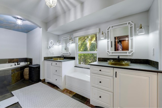 11753 Landing Pl, Palm Beach Gardens, FL 33408 - full bathroom featuring a bath, two vanities, and stone finish flooring