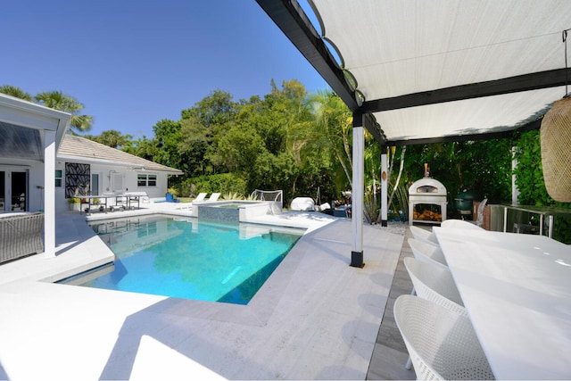 11753 Landing Pl, Palm Beach Gardens, FL 33408 - view of pool featuring a patio area, french doors, an outdoor fireplace, outdoor dining area, and a pool with connected hot tub