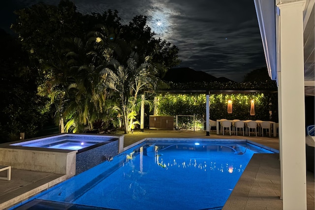 11753 Landing Pl, Palm Beach Gardens, FL 33408 - pool at twilight featuring a pool with connected hot tub and a patio