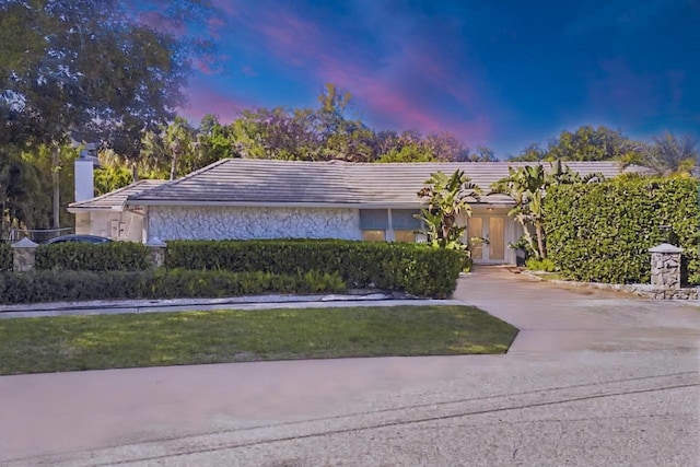 11753 Landing Pl, Palm Beach Gardens, FL 33408 - view of front of property featuring a chimney, driveway, a tiled roof, and stone siding