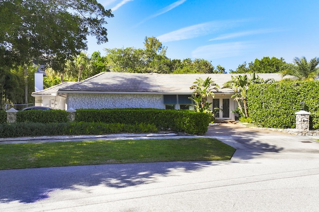 11753 Landing Pl, Palm Beach Gardens, FL 33408 - view of front of home featuring french doors, a chimney, stucco siding, and concrete driveway