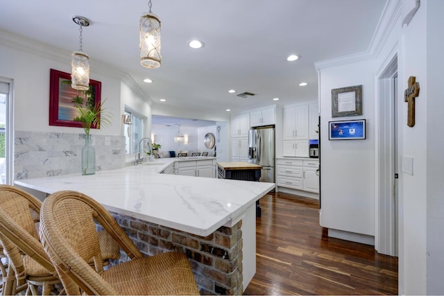 11753 Landing Pl, Palm Beach Gardens, FL 33408 - kitchen with a peninsula, stainless steel fridge, crown molding, a sink, and dark wood finished floors