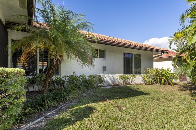 334 NW 42nd St, Boca Raton, FL 33431 - back of house with stucco siding, a tiled roof, and a lawn