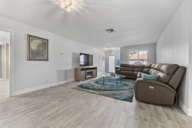 334 NW 42nd St, Boca Raton, FL 33431 - living area with visible vents, a textured ceiling, baseboards, and wood finished floors