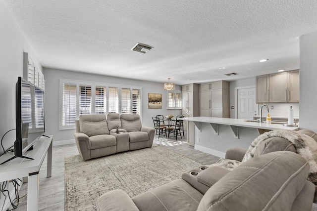 334 NW 42nd St, Boca Raton, FL 33431 - living area featuring visible vents, baseboards, light wood-style floors, and a notable chandelier