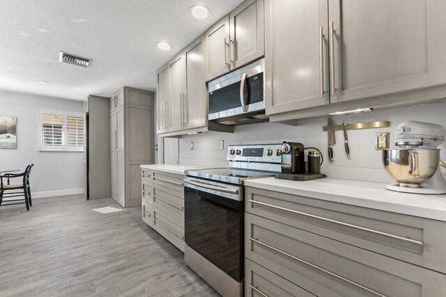 334 NW 42nd St, Boca Raton, FL 33431 - kitchen with stainless steel appliances, visible vents, and gray cabinetry