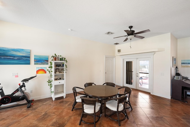 tiled dining space featuring a textured ceiling, visible vents, baseboards, and ceiling fan
