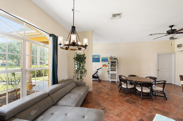 dining area with visible vents, dark tile patterned flooring, and ceiling fan with notable chandelier