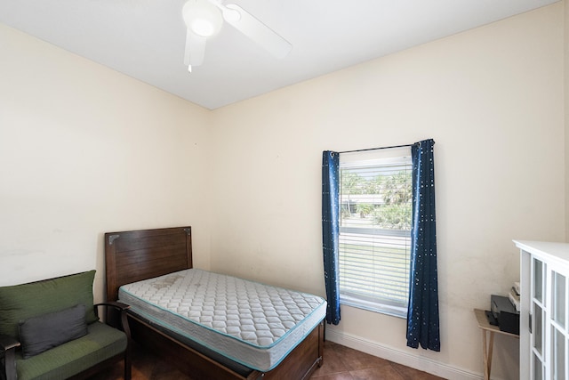 bedroom featuring tile patterned floors, a ceiling fan, and baseboards