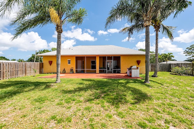 back of property with stucco siding, a sunroom, and a fenced backyard