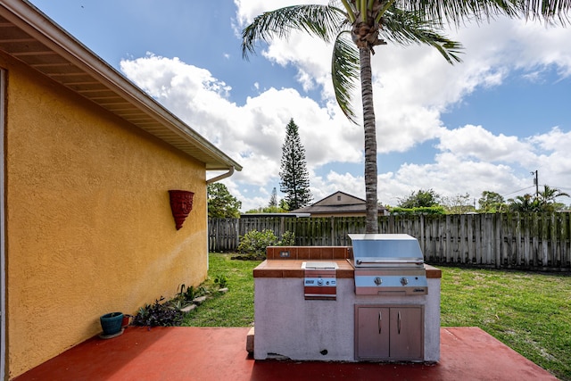 view of patio with an outdoor kitchen, a fenced backyard, and area for grilling