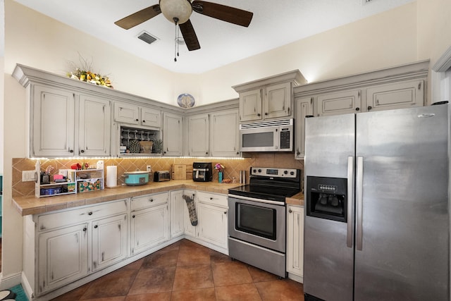 kitchen featuring tasteful backsplash, visible vents, a ceiling fan, light countertops, and appliances with stainless steel finishes
