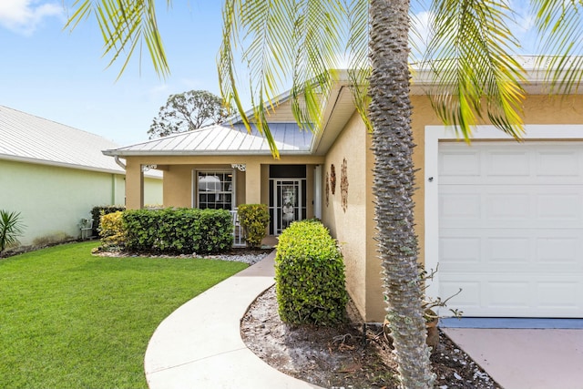 2394 SW Estella Ter, Palm City, FL 34990 - doorway to property with a garage, stucco siding, metal roof, a lawn, and a standing seam roof