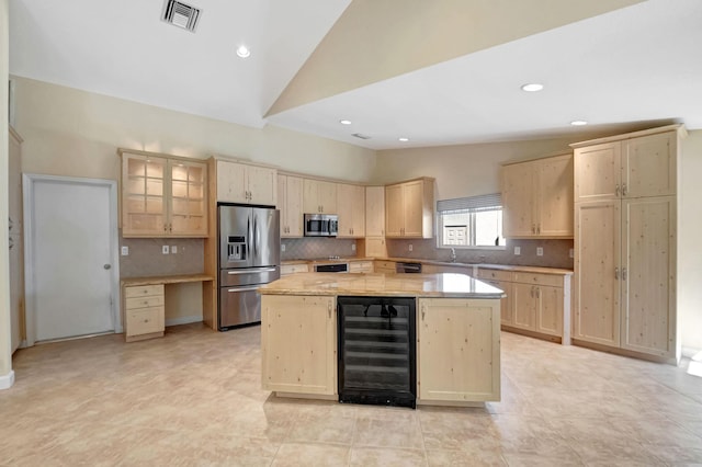 kitchen featuring stainless steel appliances, light brown cabinets, visible vents, lofted ceiling, and wine cooler